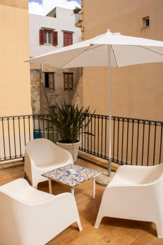 a patio with a table and chairs and an umbrella at BADIA NUOVA Apart Hotel in Trapani