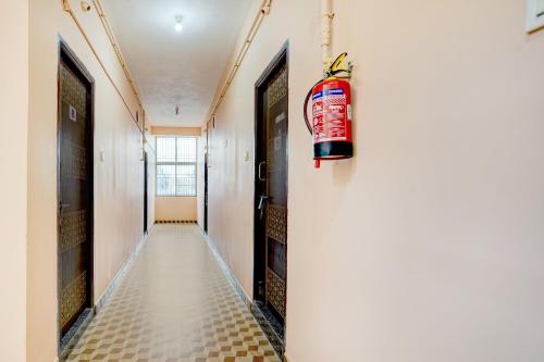 a hallway with a fire extinguisher hanging on the wall at Hotel O Karanodai Formely AVR Rooms 