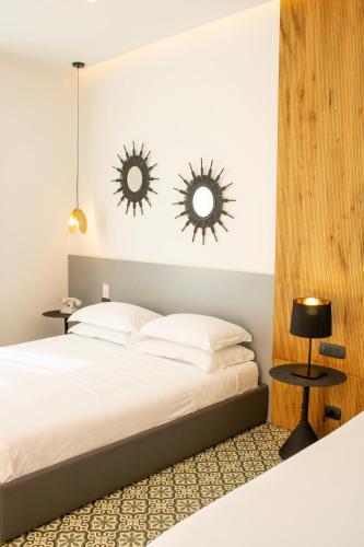 a bedroom with a bed with two mirrors on the wall at BADIA NUOVA Apart Hotel in Trapani