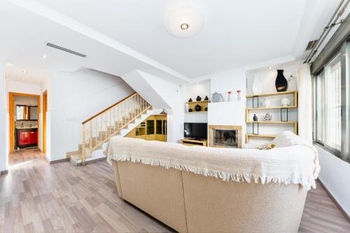 Una sala de estar con un sofá y una escalera. en Maravillas, en La Mata