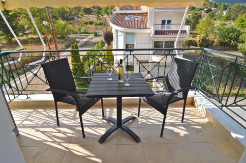 a table and chairs on the balcony of a house at Naya Lux Apt in Kastoria