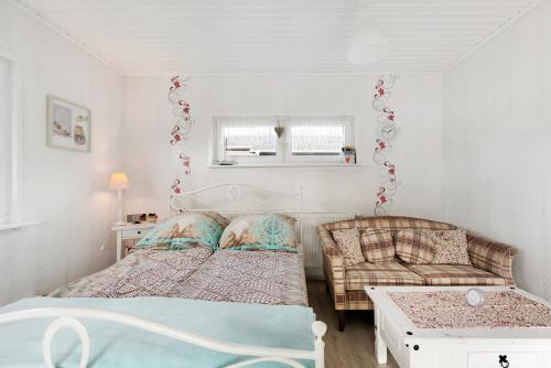 a small bedroom with two beds and a couch at Kleines Schweden in Hennstedt