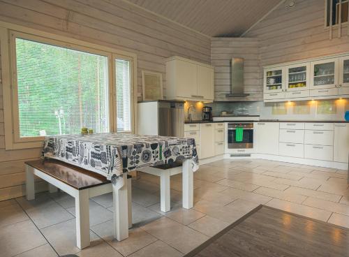 una cucina con un tavolo con una panca al suo interno di Hideout Villa Swan a Säräisniemi