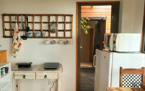a kitchen with a white refrigerator and a microwave at Mount 'n Sea Retreat Studio in Victoria Bay