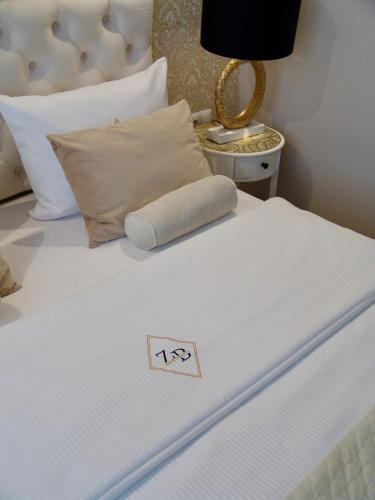 a white bed with a pillow on top of it at Apartment LUXOR - Airport Katowice-Pyrzowice in Bobrowniki