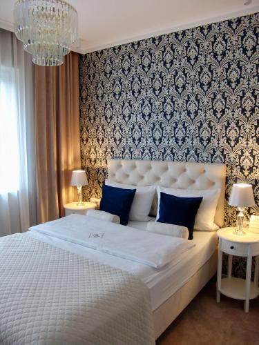 a bedroom with a large white bed with blue pillows at Apartment LUXOR - Airport Katowice-Pyrzowice in Bobrowniki