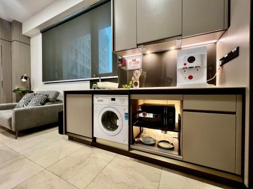 a kitchen with a washer and dryer in a room at Opus Residence KL by EUcation Home in Kuala Lumpur