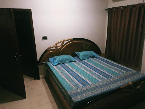 a bed with two blue pillows on it in a room at AA Digital Motel in Dargai