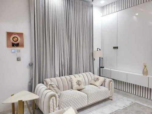 a living room with a white couch and a window at SamKash Home in Mama