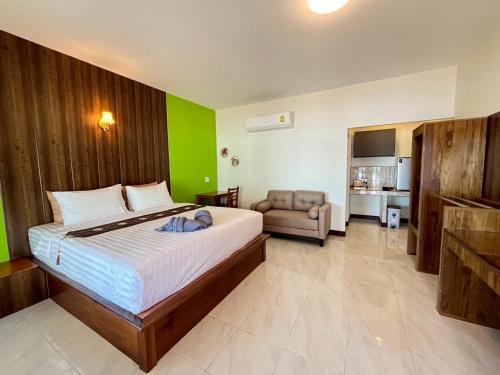 a bedroom with a large bed with a green wall at Rimlay Bay View in Ko Yao Noi