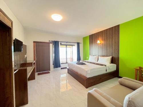 a bedroom with a bed and a green wall at Rimlay Bay View in Ko Yao Noi