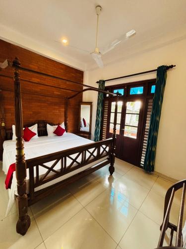 a bedroom with a large bed with a wooden headboard at SENUKi in Galle