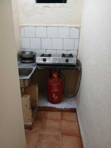 Una pequeña cocina con estufa en una habitación. en St Xavier always, en Chennai