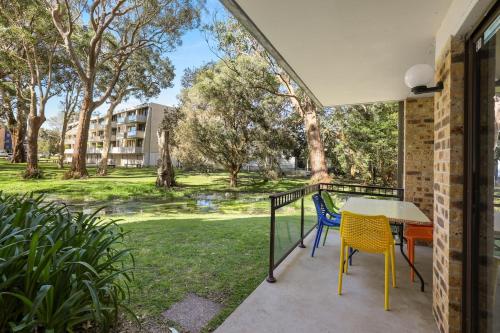 a patio with a table and chairs on a balcony at Paradise at The Bay in Nelson Bay