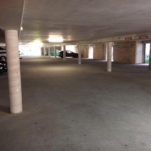 an empty parking garage with white columns and cars at Paradise at The Bay in Nelson Bay