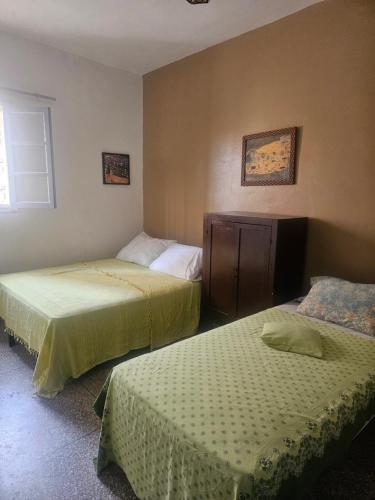 a bedroom with two beds and a window at La maison des amis in Taroudant
