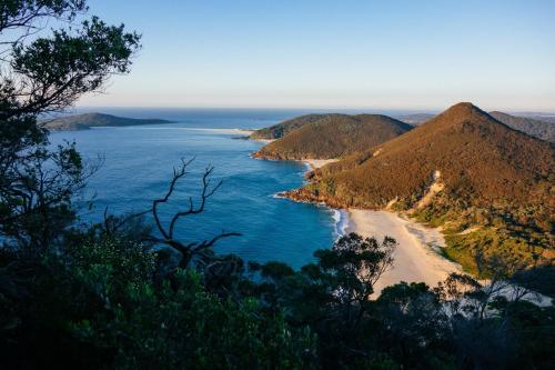 a view of a beach with mountains and the ocean at Paradise at The Bay in Nelson Bay