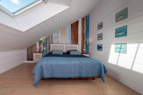 ein Schlafzimmer mit einem Bett und einem Dachfenster in der Unterkunft La Maison bleue Domainedecolomban in Carnac