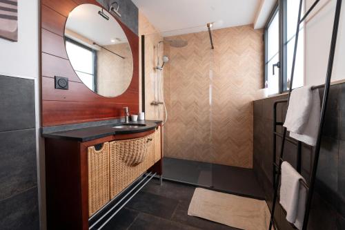 ein Badezimmer mit Waschbecken und Spiegel in der Unterkunft La Maison bleue Domainedecolomban in Carnac