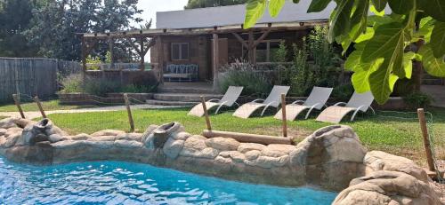 a backyard with a pool with chairs and a house at Casa Mirlo in Montmesa