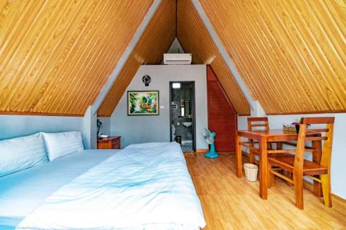 a bedroom with a bed and a desk in it at Carambola Lodge in Phong Nha
