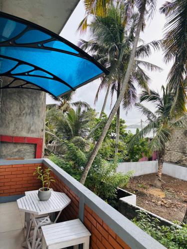 a patio with a table and chairs and palm trees at SENUKi in Galle