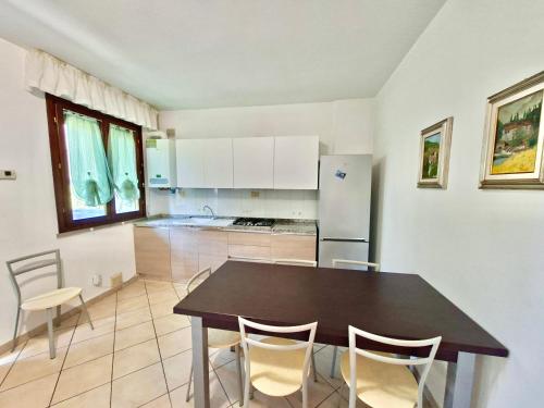 a kitchen with a table and chairs and a refrigerator at Felci 19, apartment 6 beds in Marina di Bibbona just 300 mt from the sea in Marina di Bibbona