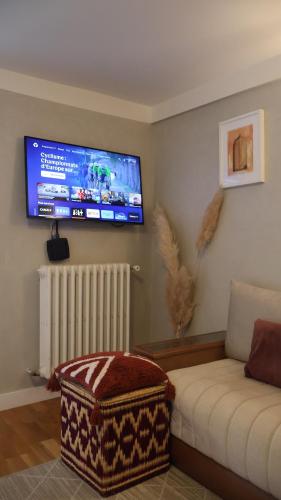 a living room with a couch and a tv on the wall at House with garden 30 minutes to Disneyland and center of Paris in Montreuil