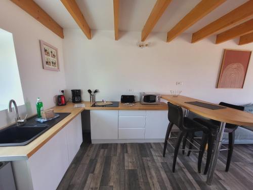 a kitchen with white cabinets and a wooden table at La marine D'opale in Ambleteuse
