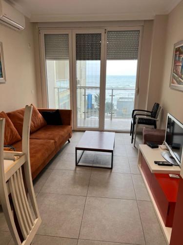 a living room with a couch and a table at Studio holidays in Shëngjin
