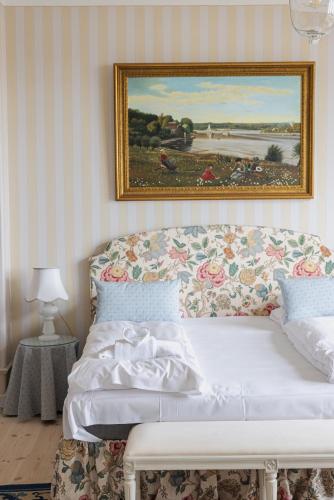 a bedroom with a bed with a painting on the wall at Aarøsund Badehotel in Haderslev