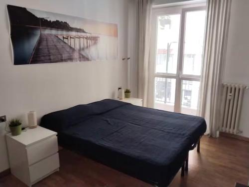 a bedroom with a bed and a painting on the wall at Camera Spaziosa in Trilocale a due passi dalla M1 in Sesto San Giovanni