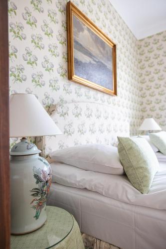 a bedroom with a bed and a picture on the wall at Aarøsund Badehotel in Haderslev