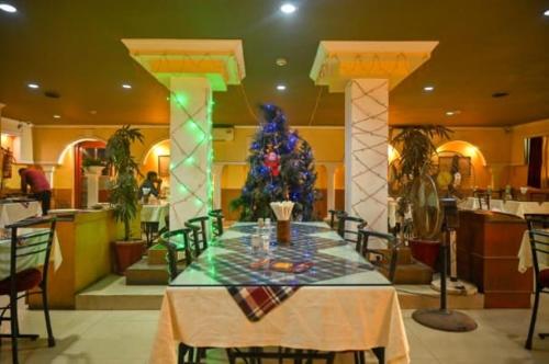 a dining room with a table and a christmas tree at Hotel Ambika in Jāmb