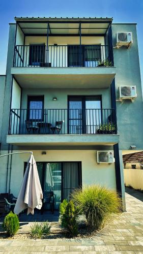 a building with a balcony with an umbrella in front of it at Feels Like Home - free parking - powered by NEO in Timişoara