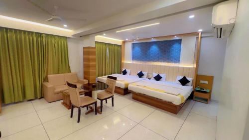 a hotel room with a bed and a table and chairs at Hotel Parqotel in Arnāla