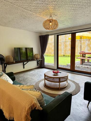 ein Wohnzimmer mit Sofa und Tisch in der Unterkunft Little Munduk, full private villa in Munduk