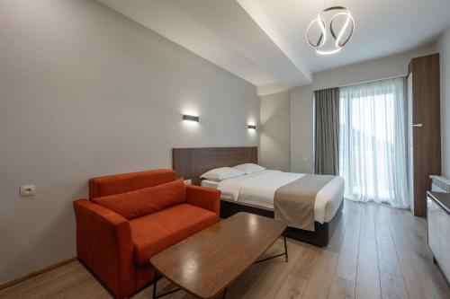 バクリアニにあるCrystal Residenceのベッドと椅子とテーブルがあるホテルの部屋