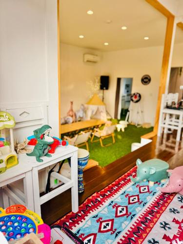 a living room with a room with a child in at Ocean House NUI in Katakai
