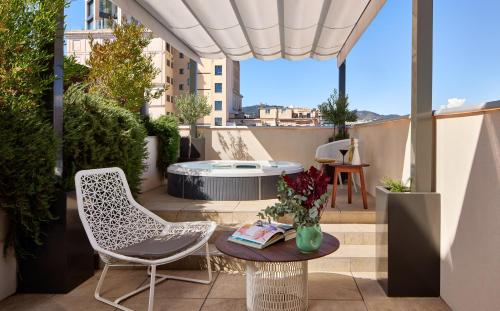 a patio with a table and chairs and a hot tub at ME Barcelona in Barcelona