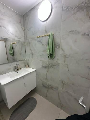 a bathroom with a white sink and a mirror at הרמוני סוויט harmony suite in Neve Zohar