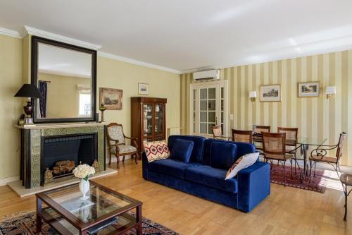 a living room with a blue couch and a fireplace at Royal Hideaway Estoril 2BR Pool Retreat in Estoril
