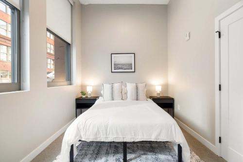 una camera da letto bianca con un letto e due finestre di Spacious 2BR CozySuites OTR Downtown #16 a Cincinnati