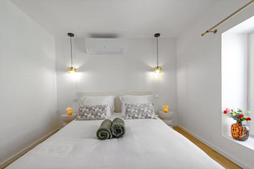 a bedroom with a white bed with shoes on it at FELIX FAURE - Somptueux 3 pièces - Carré d'Or Menton - PARKING in Menton