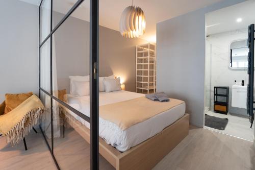 a bedroom with a bed and a glass wall at Ostend Central Residence in Ostend