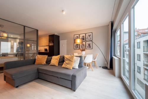 a living room with a gray couch and a table at Ostend Central Residence in Ostend