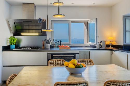 a kitchen with a table with a bowl of fruit on it at Maison de pêcheur dans le Cap Corse in Erbalunga