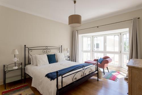 a bedroom with a bed and a large window at Royal Hideaway Estoril 2BR Pool Retreat in Estoril