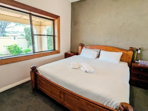 a bedroom with a wooden bed with a window at Cosy Lodge Mount Gambier close to shopping, eating in Mount Gambier