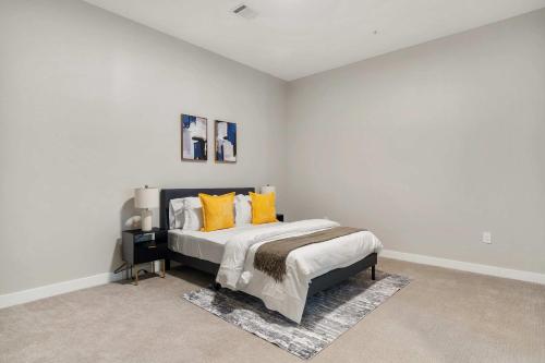 una camera da letto con un letto con cuscini gialli di CozySuites Modern 3BR OTR District #18 a Cincinnati